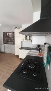 a kitchen with a black stove top oven in a kitchen at Appartamento Taverna Gattolini in Venzone