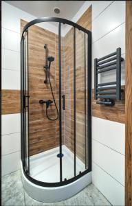 W łazience znajduje się prysznic ze szklanymi drzwiami. w obiekcie Villa Krotoszyce w mieście Krotoszyce