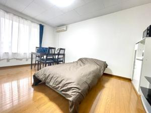 a bed in a room with a table and chairs at Avidasion - Vacation STAY 13342 in Biei