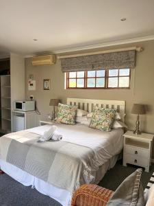 a bedroom with a large white bed and a window at Bunkers Inn Guesthouse in East London