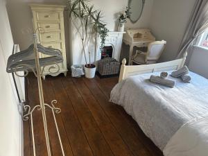 um quarto com uma cama, uma cómoda e uma lareira em April Cottage Ringwood em Ringwood