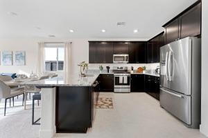 a kitchen with black cabinets and a stainless steel refrigerator at Stylish 4BR Home Nr Golden Eagle Sports Complex in Sparks