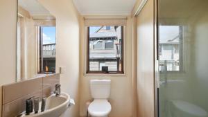 a bathroom with a toilet and a sink and a window at Breck in Dinner Plain +3 photos