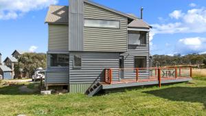 a house with a large deck on the side of it at Breck in Dinner Plain