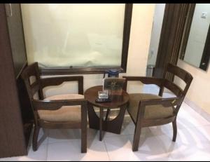 a table and two chairs and a table and a table and chairs at hotel Priya Palace BY BYOB Hotels in New Delhi