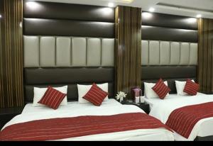 a bedroom with two beds with red and white pillows at hotel Priya Palace BY BYOB Hotels in New Delhi