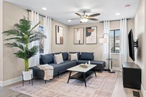 a living room with a blue couch and a palm tree at Elegant 4BD Reno Abode, close to Shops and Casinos in Reno
