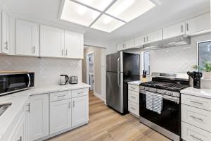 a kitchen with white cabinets and a black stove top oven at Elegant 4BD Reno Abode, close to Shops and Casinos in Reno