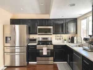 a kitchen with black cabinets and stainless steel appliances at Reno Gem 3 and a half Miles to DT, 40 Miles to Tahoe in Reno