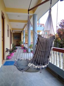 une terrasse couverte avec un hamac sur un balcon dans l'établissement Hotel Mirage Sauraha, à Sauraha