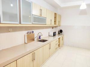 a kitchen with wooden cabinets and a sink at Puchong Landed Homestay - 2nd unit @ BKT Puchong in Puchong