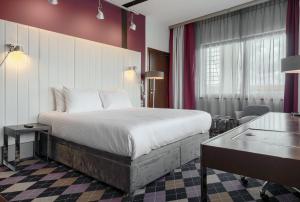 a hotel room with a bed and a desk at Qubus Hotel Bydgoszcz in Bydgoszcz