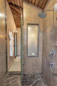 a shower with a glass door in a bathroom at The Baga Beach Resort in Baga