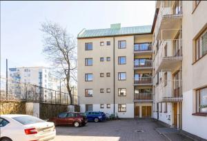 タンペレにあるKolmio Tampereen ydinkeskustassaの駐車場に駐車したアパートメントビル