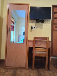 una puerta que conduce a una habitación con escritorio y TV en Hotel Mirage Sauraha en Sauraha