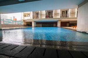 a large swimming pool in the middle of a building at Tamansari Sudirman Apartment in Jakarta