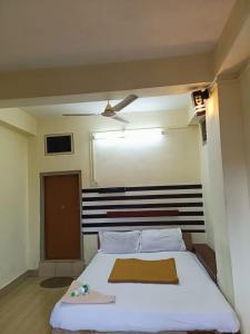 een slaapkamer met een wit bed en een zwart-wit hoofdeinde bij Hotel Orginal Residency in Kollam