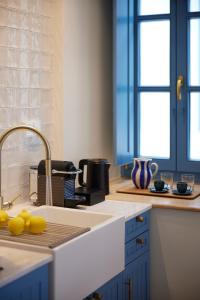 a kitchen with a sink and a counter with lemons on it at Orloff Legacy Suites Hydra in Hydra