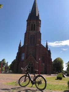 a bike is parked in front of a church at Landhaus Saterland Ferienwohnung NEU Emsland Ostfriesland Nordsee in Sedelsberg
