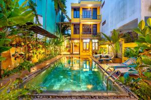 een huis met een zwembad voor een gebouw bij Hoi An Green Riverside Oasis Villa in Hội An