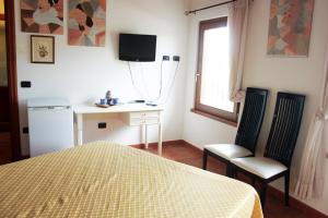 a bedroom with a bed and two chairs and a desk at Bio Agriturismo Vojon in Ponti Sul Mincio