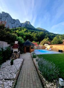 a backyard with a stone pathway and a gazebo at Casa Jax in Rîmeţi