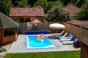 a backyard with a pool with chairs and an inflatable raft at Casa Jax in Rîmeţi