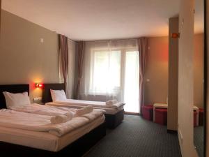 2 camas en una habitación de hotel con ventana en Chillhouse Bed & Breakfast, en Bakʼovo