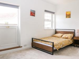 een slaapkamer met een bed en een raam bij Burfield Cottage in Windsor