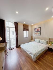 een slaapkamer met een groot bed en een groot raam bij Amy Apartment Hue in Hue