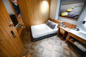 um pequeno quarto com uma cama e um lavatório em La Opera Saigon Hotel em Cidade de Ho Chi Minh