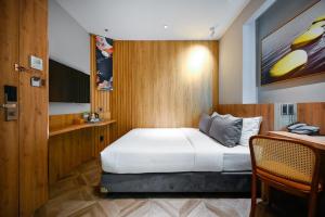 ホーチミン・シティにあるLa Opera Saigon Hotelのベッドとテレビが備わるホテルルームです。