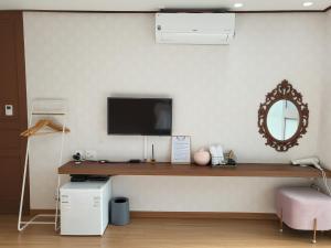 um quarto com uma secretária, uma televisão e um espelho em Cheukhu-dong 19street Guesthouse em Mokpo