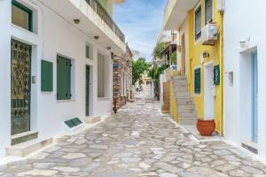 a cobblestone street in a town with buildings at Apano Vrysi Tinos 4 in Tinos Town