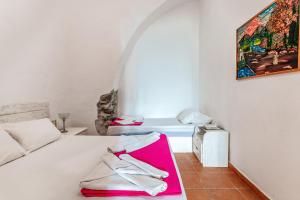 a room with a bed and a painting on the wall at Apano Vrysi Tinos 4 in Tinos Town