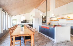 a kitchen and dining room with a wooden table and chairs at Stunning Home In Spttrup With 8 Bedrooms, Sauna And Indoor Swimming Pool in Vadum