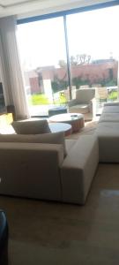 una sala de estar con sofás blancos y una ventana grande. en Villa, en Marrakech