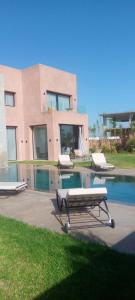 un edificio con una piscina de agua con dos mesas. en Villa, en Marrakech