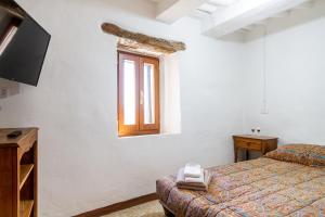 a bedroom with a bed and a tv and a window at La casa di Maffin in Roccastrada
