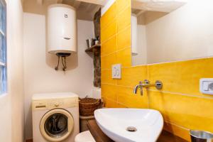 a bathroom with a sink and a washing machine at La casa di Maffin in Roccastrada