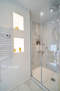 a shower with a glass door in a bathroom at The Golden white, Luxury T3 in Annecy