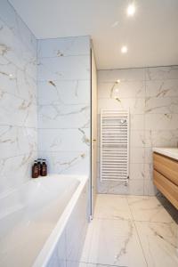 uma casa de banho branca com uma banheira e um chuveiro em The Golden white, Luxury T3 em Annecy