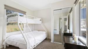 a bedroom with a bunk bed and a mirror at Krystal Peaks in Dinner Plain