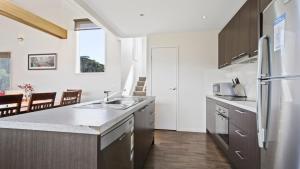 a kitchen with a sink and a refrigerator at Krystal Peaks in Dinner Plain