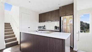a kitchen with a sink and a refrigerator at Krystal Peaks in Dinner Plain