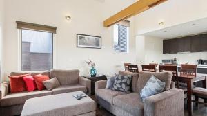 a living room with two couches and a dining room at Krystal Peaks in Dinner Plain