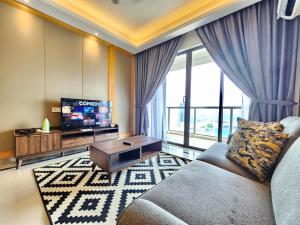 a living room with a couch and a tv at R&F Princess Cove CIQ Premium Sea View Suites by NEO in Johor Bahru
