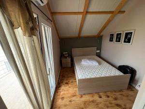 Habitación pequeña con cama y ventana en Attic View, en Loutsa