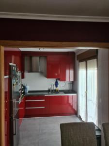 a kitchen with red cabinets and a refrigerator at URIFER in Cóbreces