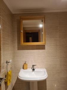 a bathroom with a white sink and a mirror at URIFER in Cóbreces